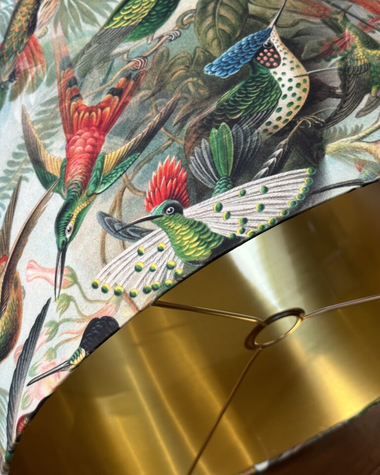 Close-up of tropical hummingbird pattern on handmade lampshade with gold lining — Chantier Studio lighting.